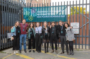Joyful faces full of expectation in front of the entrance to the so-called glass house at Arena Berlin, this year's venue of the Max Planck Schools Day 2023. Doctoral candiates in front of Arena Berlin