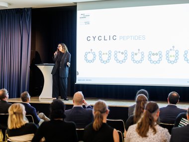 Lecture on cyclic peptides with diagrams on a screen.