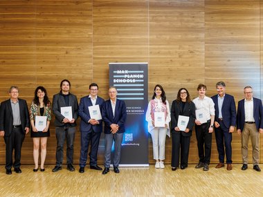 Group in front of a Max Planck Schools banner, several holding certificates.