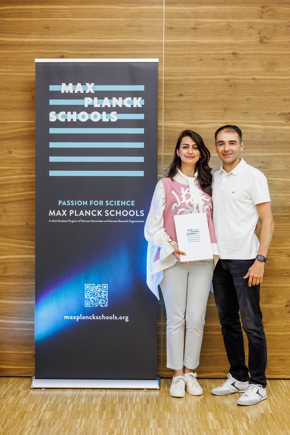 Max-Planck-Schools-Banner und zwei Personen.