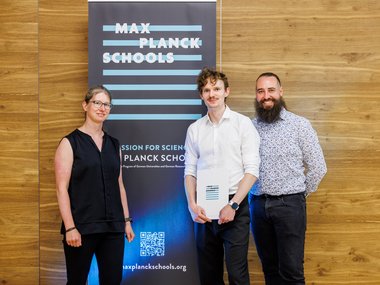 Wooden panel wall with Max Planck Schools banner, QR code, and text about science.