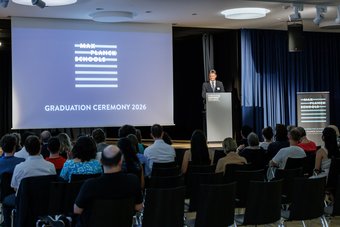 Zum Auftakt begrüßten die beiden Deans der Max Planck Schools – Joachim Hornegger, Präsident der FAU Erlangen-Nürnberg, und Jan-Michael Rost, Direktor am Max-Planck-Institut für Physik komplexer Systeme – das Publikum herzlich. Veranstaltungsraum mit sitzendem Publikum bei der Abschlussfeier 2026 der Max-Planck-Schools, Redner am Podium neben Projektionsfläche mit Veranstaltungstitel.